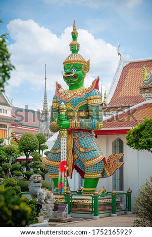 Giants front of the church at Wat Arun or Temple of dawn a tourist landmark in Bangkok Thailand. Wat Arun is a tourist destination and famous landmarks in Thailand. Travel attraction. Vintage picture.