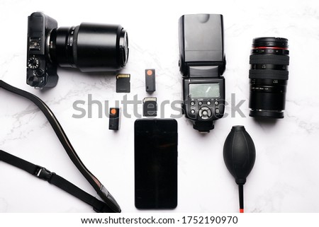Flatlay of camera gear on marble table with copy space smartphone.