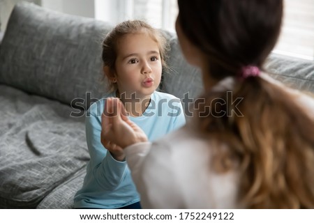 Small preschooler disabled girl practice nonverbal talk with female nanny or tutor at home, cute little child make hand gesture learn speak sign language with mother, children disability concept Royalty-Free Stock Photo #1752249122