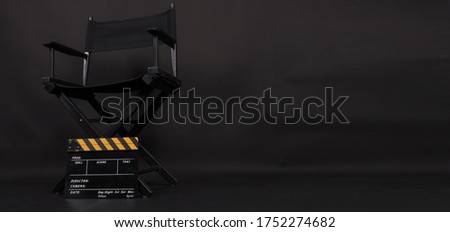 Director chair and Clapper board or movie slate use in video production or film and cinema industry. It's put on black blackground. Royalty-Free Stock Photo #1752274682