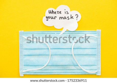 top view of medical mask with speech bubble on yellow background
