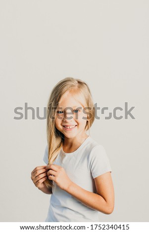 Beautiful little blonde girl posing in studio