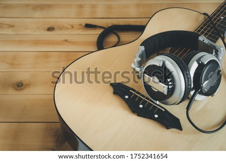 Table top view of music instrument tools concept background.Flat lay of sign to sing for musician or party equipment.Guitar with headphone on rustic wooden.copy space for creative design. 
