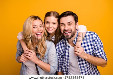 Photo wife beautiful mother lady husband dad guy couple carry little school girl daughter piggyback happy together play weekend laughing wear casual clothes isolated yellow color background