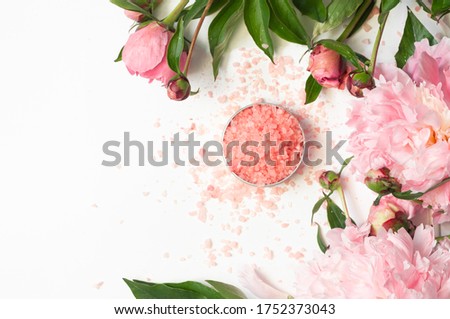 Natural organic cosmetic products with pink peonies flowers on white background. Spa relax Treatments and anti-cellulite massage. Beauty, nature cosmetics for bath spa, skin care, flat lay.