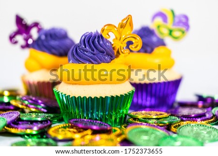 Mardi Gras vanilla cupcakes in foil cupcake cups and decorated with Italian buttercream frosting.