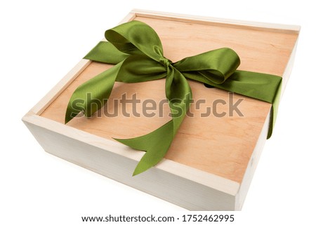 Wooden gift box with green ribbon on white background. Top view.