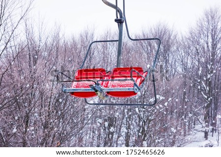 Chairlift in the mountains, winter view of the spores, rest in the mountains, skiing, red seats