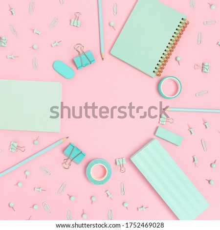 Round frame made of mint color school supplies on a pink pastel background. Artistic concept with copy space.