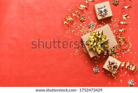Beautiful composition. Festive red background with gifts and ribbons. View from above.
