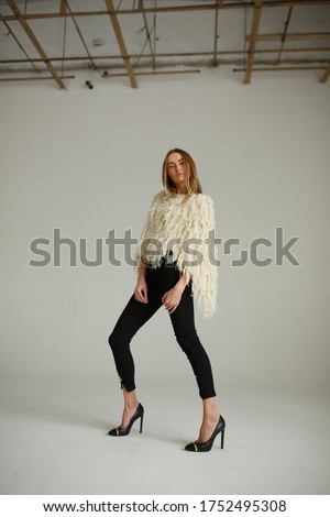 fashion look girl in black pants  and white top on plane studio background, supermodel posing, copy space