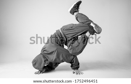 A man hip hop dancer or bboy freezes in one pose on a white background. Bboy doing stylish stunts. Royalty-Free Stock Photo #1752496451