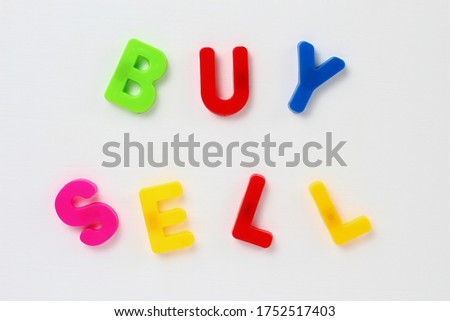 Text made by magnetic letters on a white wooden background. BUY SELL. Business Success Motivation
