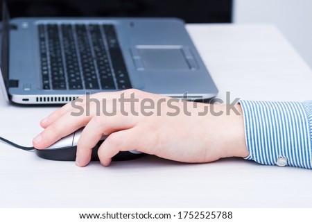 Lefthander using computer mouse with left hand. Left handed day concept.