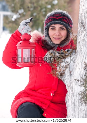 Girl with red lantern in the snow