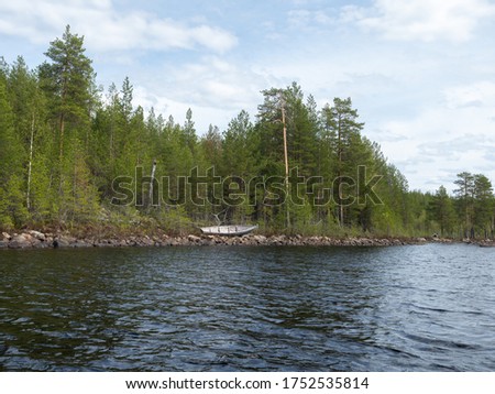 Traditional wooden fishing boat in the bank of the lake in Karelia, northwest of Russia