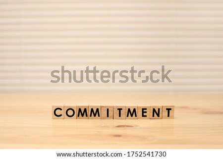 Commitment, word text typography written on wooden alphabet letterpress cubes 