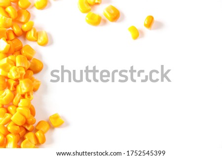 Corn, yellow grains of canned corn are scattered on a white background from above.