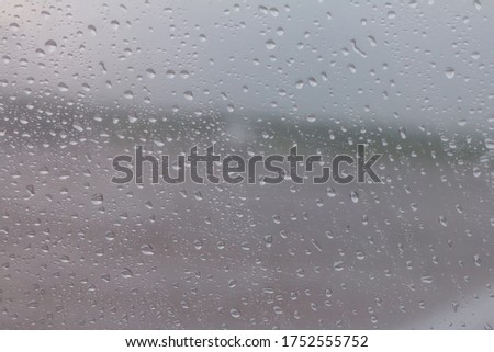 The raindrops are attached to the clear glass in front of the car. When it rains During the day time, the picture is partially clear.