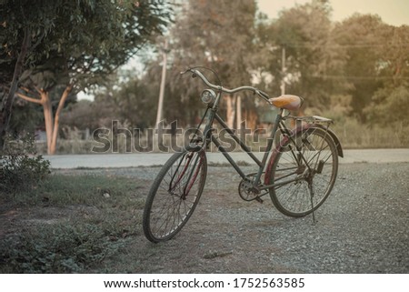 Landscape picture Vintage Bicycle with Summer grass field at sunset. color of vintage tone and soft focus concept journey.close up