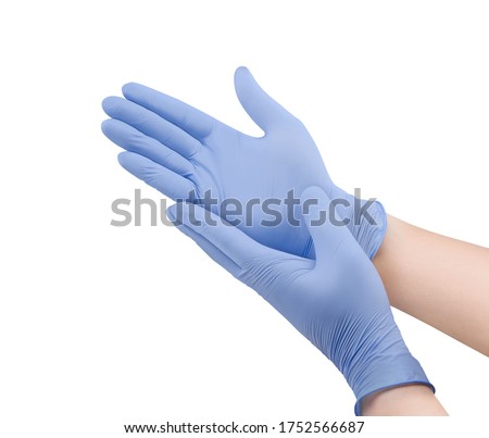 Medical nitrile gloves.Two blue surgical gloves isolated on white background with hands. Rubber glove manufacturing, human hand is wearing a latex glove. Doctor or nurse putting on protective gloves Royalty-Free Stock Photo #1752566687