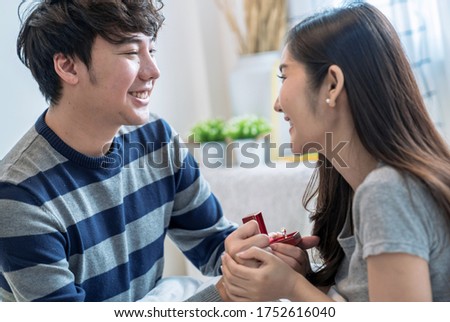 Happy asian couples, The young man gave a gift to his lover, The girl is excited and happy when receiving the gift.