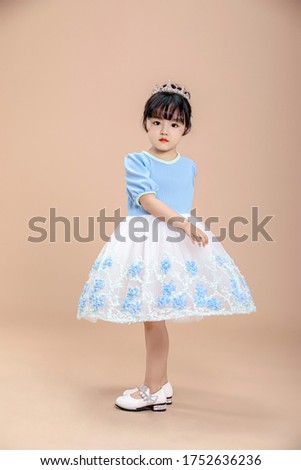 Cute beautiful asian little girl in blue dress shooting in the studio