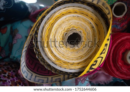 yellow roll of fabric in the store with a fabric background