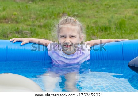 a small pool of blue color. A girl with white hair bathes in it.