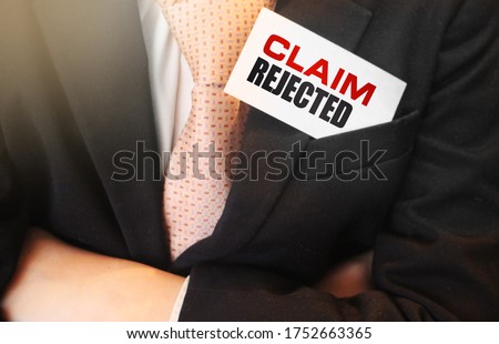 Card with text Claim Rejected in the pocket of businessman wearing tie and a suit. Business concept.