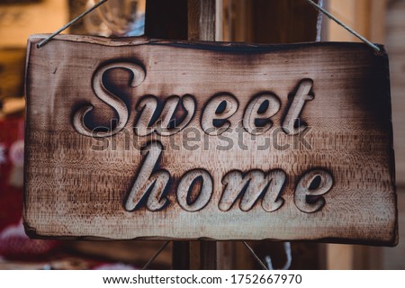 Home sweet home letters on a wooden plate. Deified tree. Decoration for the interior or garden. Handmade