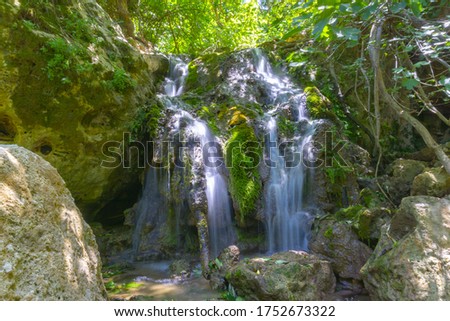 Beautiful waterfall in the forest. Long exposure shot. Wild nature, national park, hiking touristic path.
