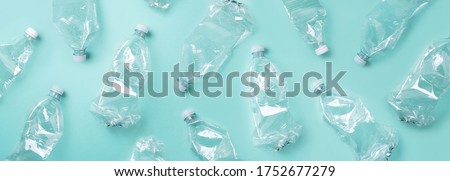 Empty rumpled used plastic bottle on blue background. Top view, copy space. Pollution, environmental protection concept. Reuse garbage, recycle, plastic free. Earth, world water day. Royalty-Free Stock Photo #1752677279