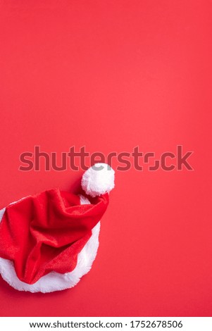 Top view of Santa's hat on red background. Christmas, New year, winter holidays season concept. Banner. Top view. Copy space. Advent time. Festive greeting card.