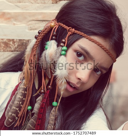 Little girl playing dress-up as Native American, wearing Indian headdress. Cute little girl playing in teepee.  Boho style.
 Royalty-Free Stock Photo #1752707489