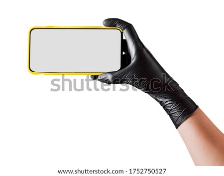Hand in black glove holding mobile phone with blank screen on white background. Isolated with clipping path.