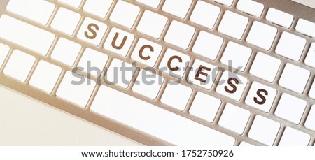 detail of white keyboard with the word SUCCESS on the space bar. concept of smart working