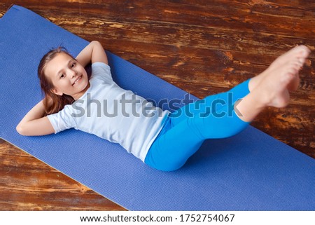 Slim healthy mother, charming funny little daughter balancing while doing in tree pose family together at home. Horizontal picture with copy space for text or advertising sales. Sport beauty concept.
