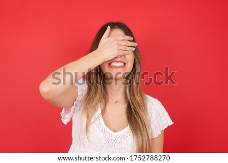 Happy Caucasian young woman closing eyes with hand going to see surprise prepared by boyfriend standing and smiling in anticipation for something wonderful. Young lady covering face with hand. Royalty-Free Stock Photo #1752788270