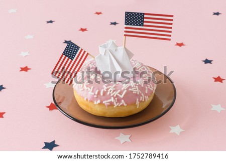 Figure of man hold two american flag and stands on a donut. 4th of july in America, celebration independence day in usa, good mood. Pink background with star.