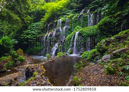 Tropical landscape. Beautiful hidden waterfall in rainforest. Adventure and travel concept. Nature background. Slow shutter speed, motion photography. Banyu Wana Amertha waterfall Bali, Indonesia