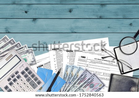 IRS form 1065 U.S. Return of partnership income lies on flat lay office table and ready to fill. U.S. Internal revenue services paperwork concept. Time to pay taxes in United States. Top view Royalty-Free Stock Photo #1752840563