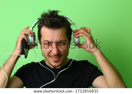 Expressive young man or guy on a light green background. Emotion of fatigue and strain