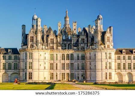 Chateau de Chambord in summer, France. It is tourist destination in Loire Valley, World landmark. Ornate exterior of French castle of Chambord in sunset light. Theme of Renaissance castle and travel.