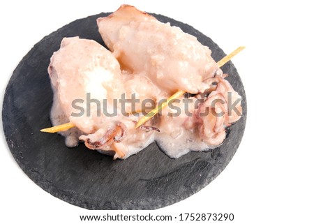A picture of "ketupat sotong" on slate table white background. Glutinous rice stuffed in squid that is famous East Coast of Malaysia.