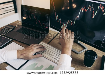Close up of hand investors are pointing to laptop computer that have investment information stock markets and partners taking notes and analyzing performance data.