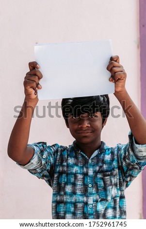 Portrait of an African American kid holding white paper