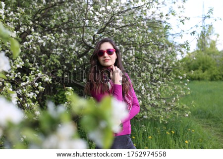 portrait of a beautiful woman with brown hair on a background of a blooming garden