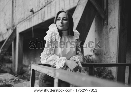 Portrait of a young woman in blouse and jeans in a lost place