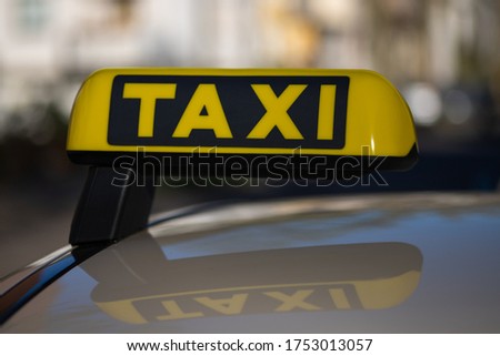 taxi sign on the Roof of a cab with reflection and blurry background